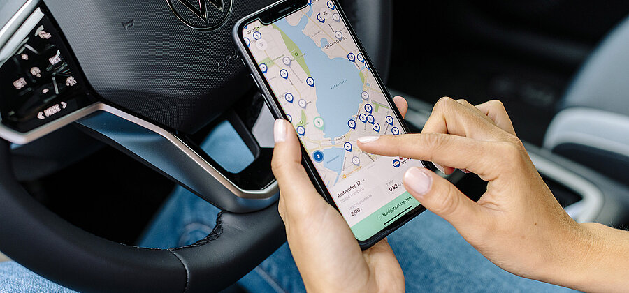 Eine Hand bedient eine Navigationsoftware auf einem Handydisplay